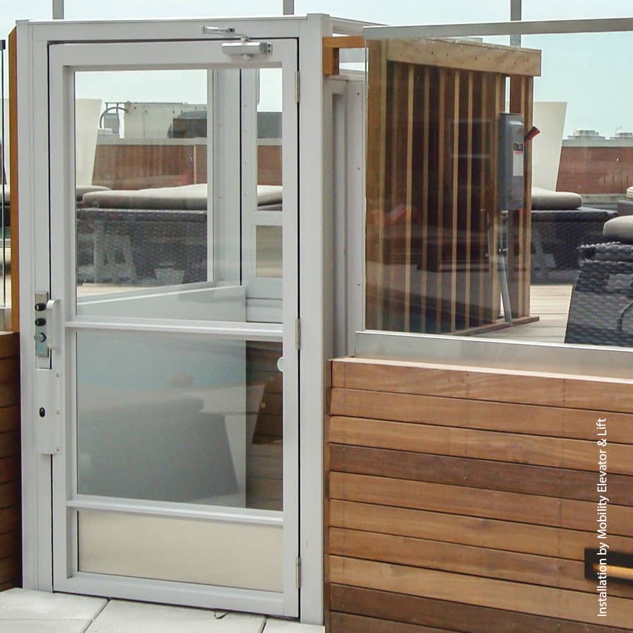 White Multilift enclosed vertical platform lift connecting residential deck to ground level entrance