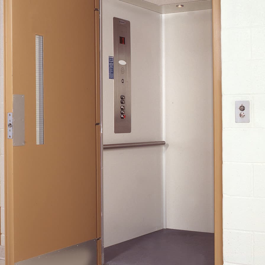 Accessible LU/LA Prolift vertical platform lift with code-compliant door and stainless steel car operating panel.