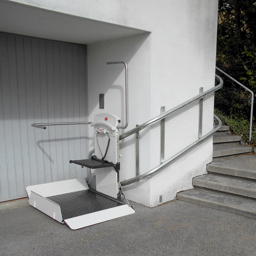 Savaria Pegasus Inclined Platform Lift (IPL) designed for custom curved outdoor staircases sitting on the ground outside of a white building