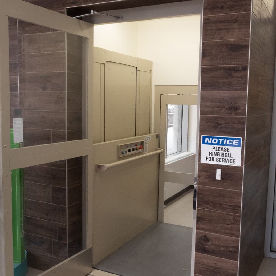 V-1504 Standard wheelchair lift in beige color with an open door