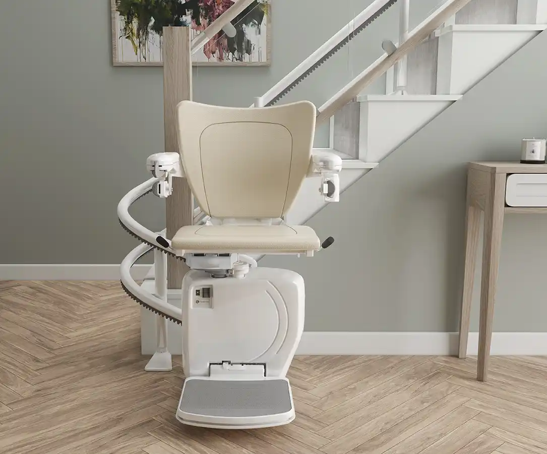Savaria Handicare 4000 twin-rail curved stairlift with Simplicity Seat in vanilla, power swivel at 180 degrees, custom curved track, and charging station at bottom landing